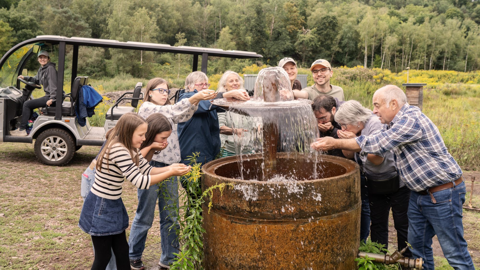 Besucher am Brunnen in der Grube