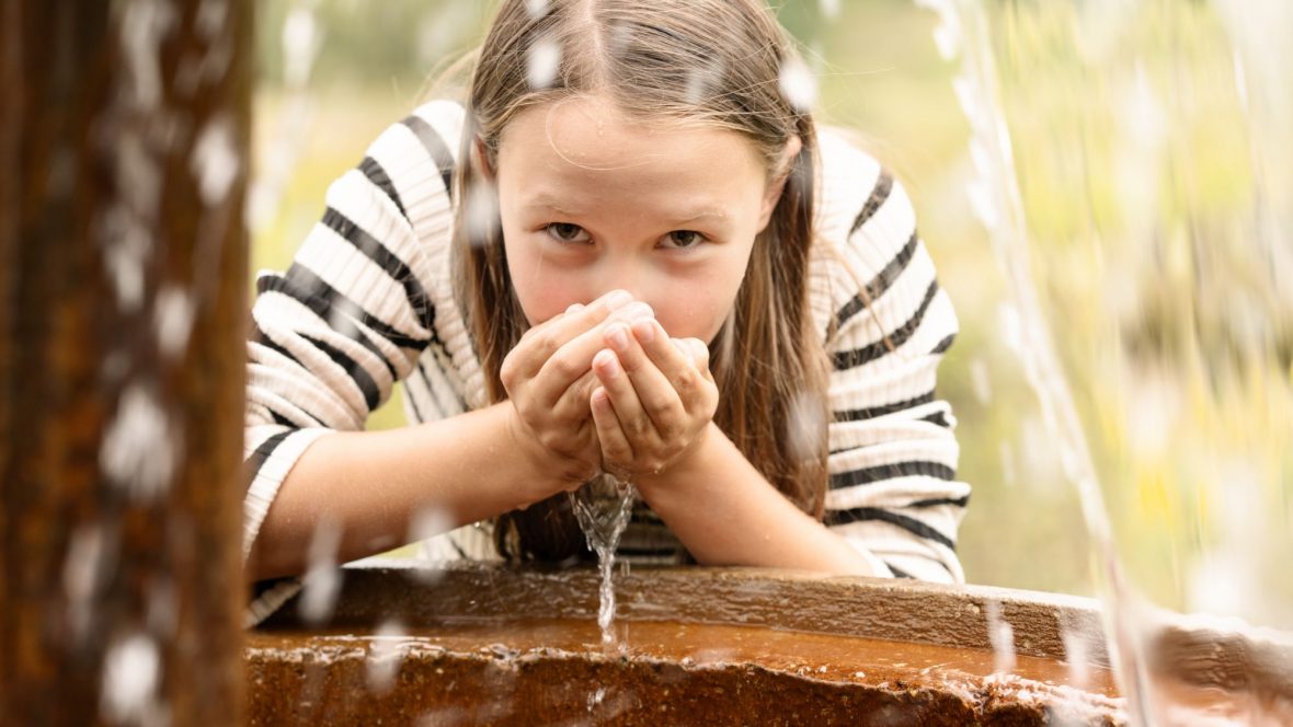 Wasser probieren am Brunnen in der Grube